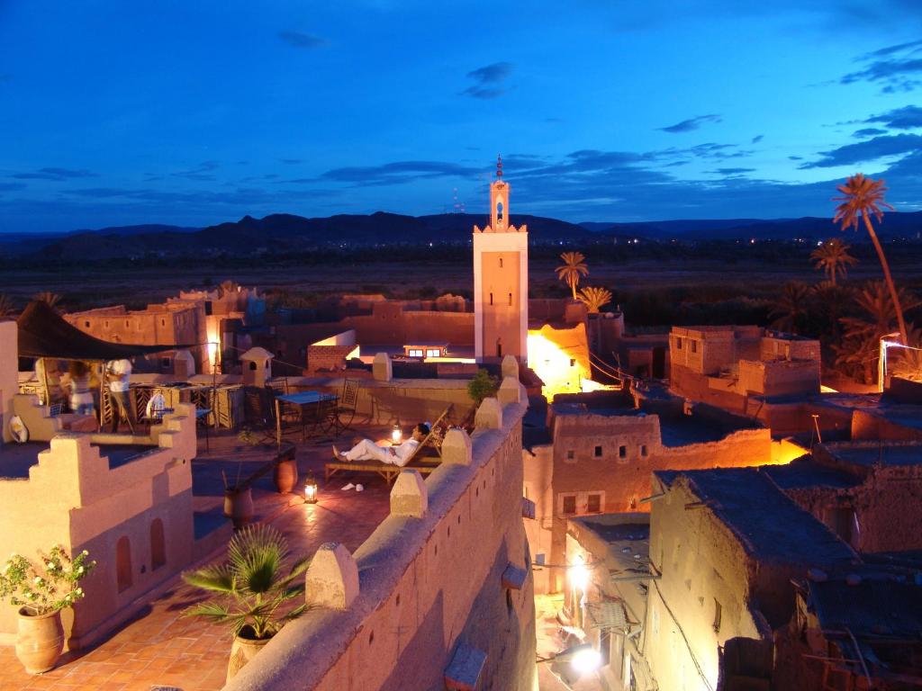 瓦尔扎扎特达尔卡玛旅馆的享有小镇的夜间美景,设有钟楼