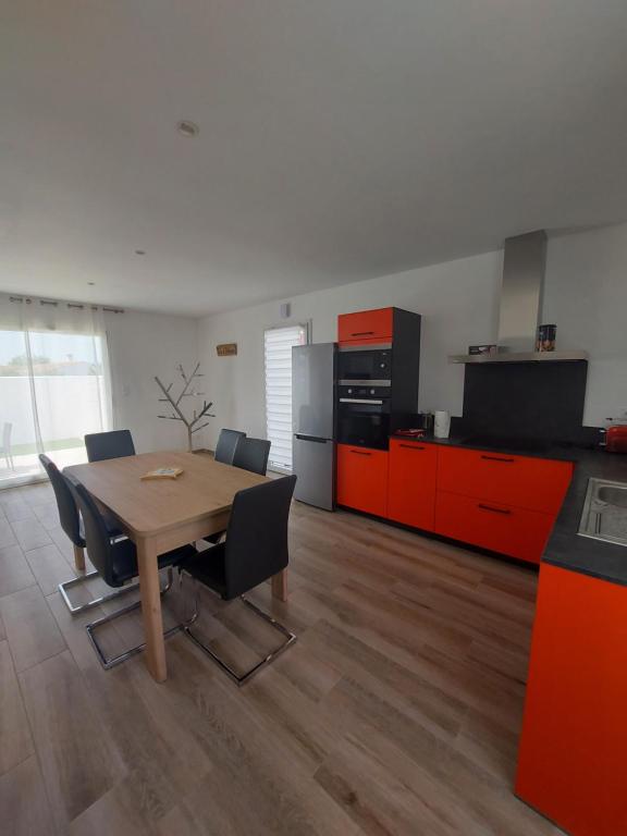 拉康提内勒A bâbord : maison chaleureuse à 300m de la plage的厨房配有桌子和一些橙色橱柜