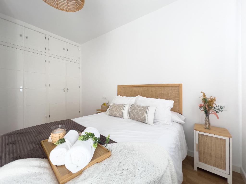 普拉森西亚Apartamentos Turísticos Con Alma的一间卧室配有一张床,上面放着鲜花