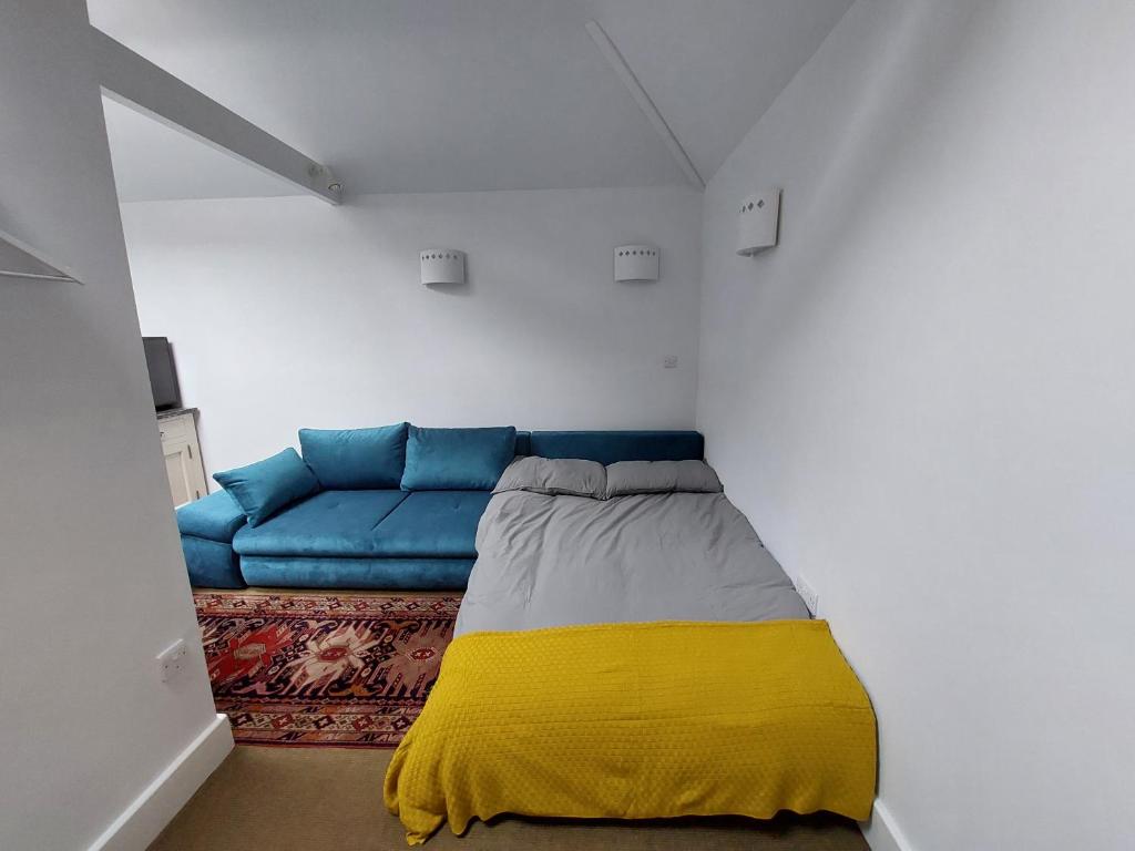 西卢港Peaceful Self-contained room near Looe的客厅配有蓝色的沙发和黄色的毯子