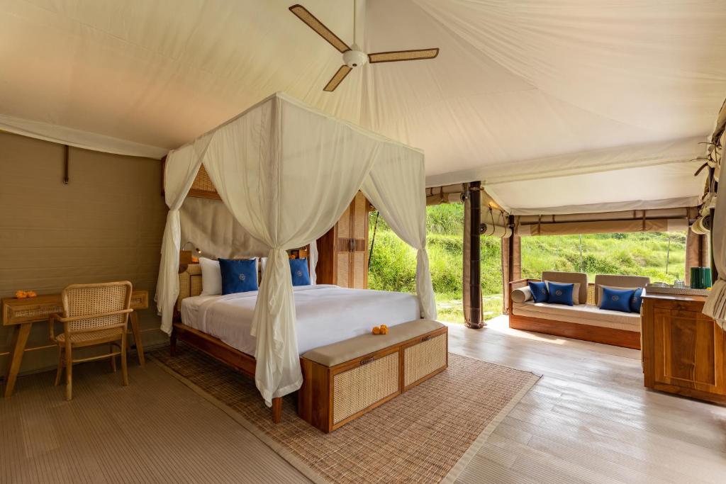 塔巴南Nadi Nature Resort - Adults Only的一间卧室配有一张天蓬床和一张书桌