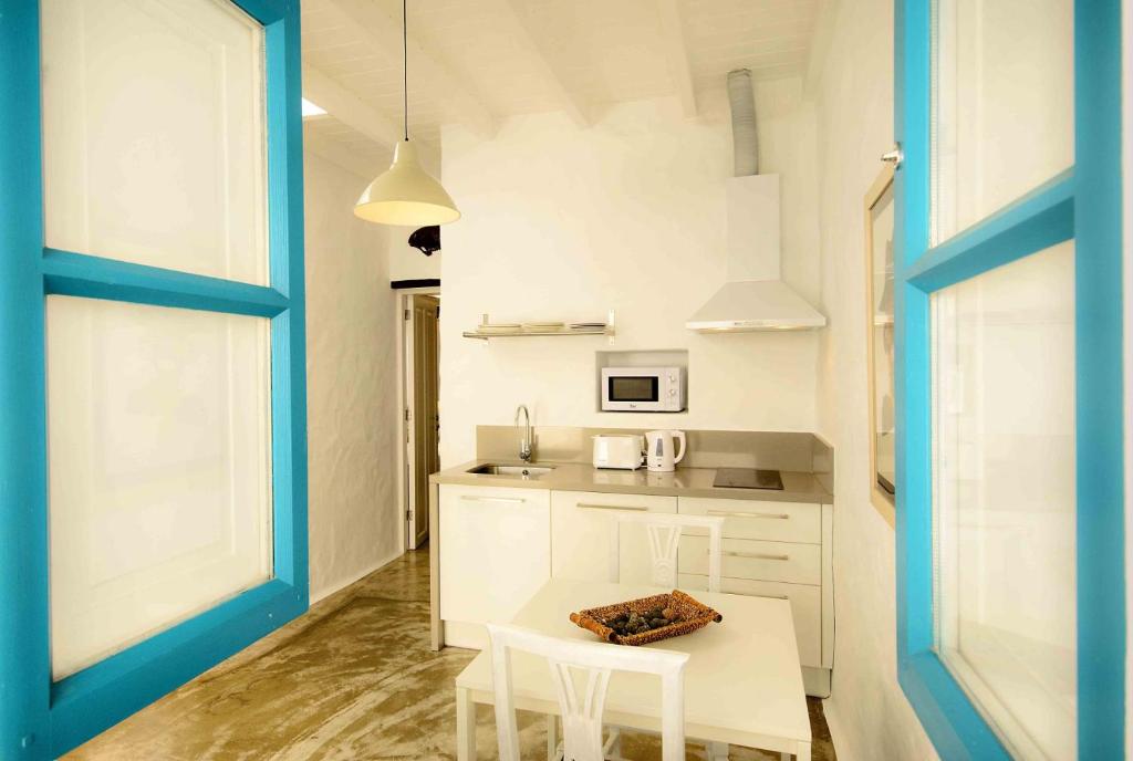 蓬塔穆赫雷斯萨利纳斯公寓的厨房配有白色橱柜和桌椅