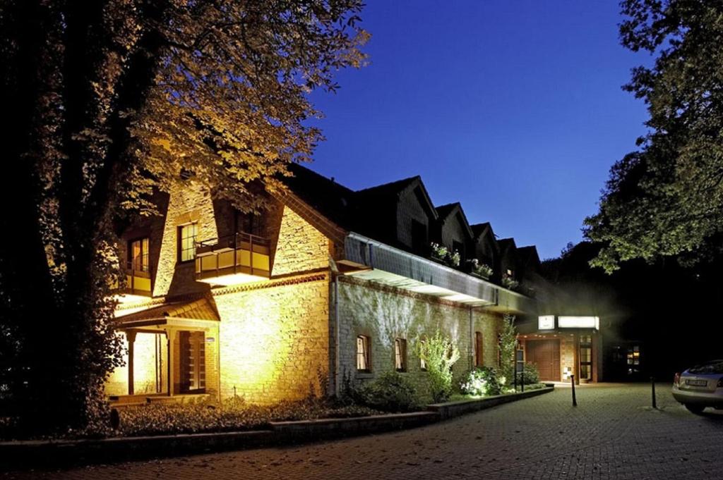 奥斯纳布吕克布希-阿特酒店的夜晚,房子的一侧有灯