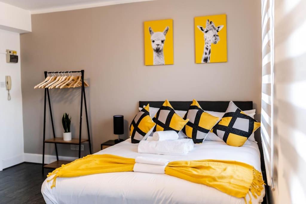 伦敦Charming Studio Retreat I1Bed1Bath Haven in London的一间卧室配有一张带黄色和黑色枕头的床