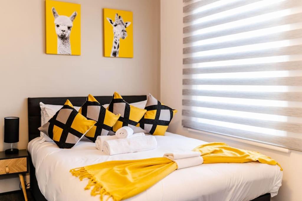 伦敦Charming Studio Retreat I1Bed1Bath Haven in London的一间卧室配有一张带黄色和黑色枕头的床