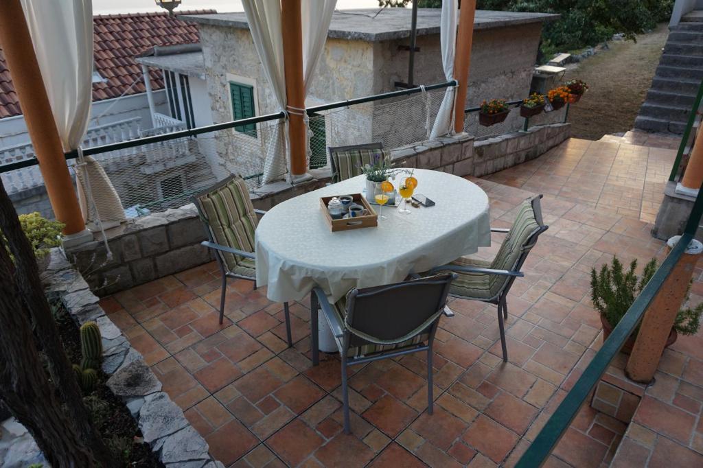 巴什卡沃达Holiday House Terezija的庭院里的白色桌椅