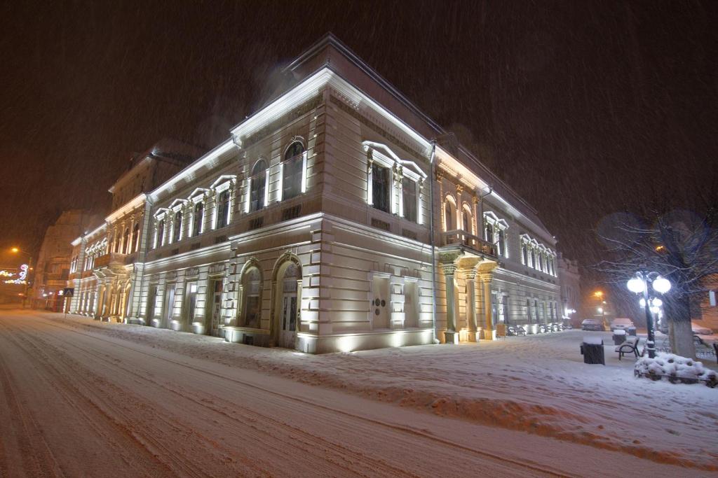 坎普朗莫道尼斯Buchenland Hotel的夜间在积雪的街道上被点亮的建筑物