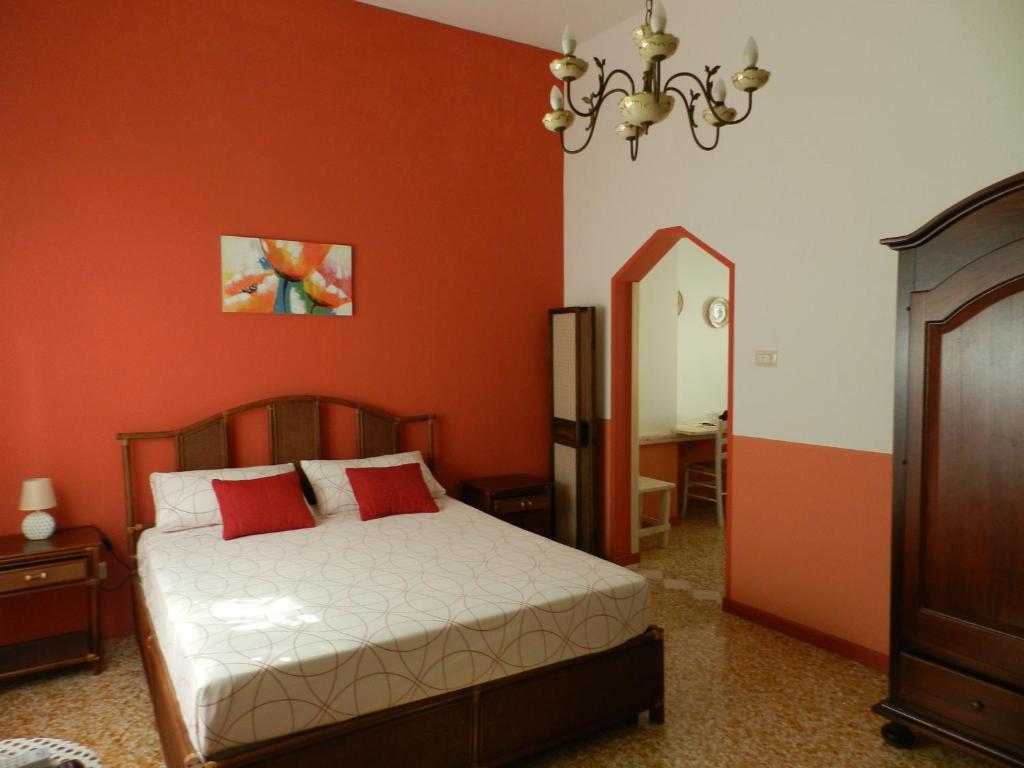 塔维亚诺Casa a Corte nel centro storico的一间卧室配有一张带红色墙壁和镜子的床