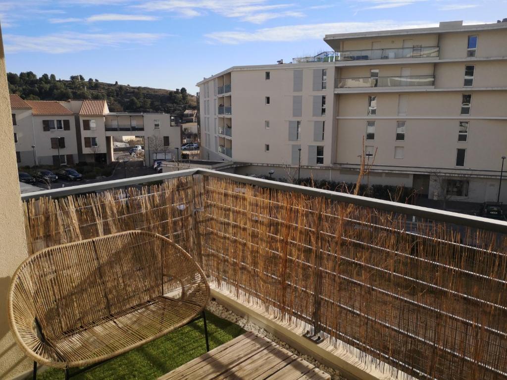 塞普特梅斯·莱瓦隆T2 tout neuf avec Parking à 10km d'Aix et Marseille的大楼阳台的长凳