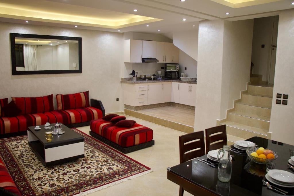 马拉喀什Magnifique Duplex à Marrakech的一间带红色沙发的客厅和一间厨房