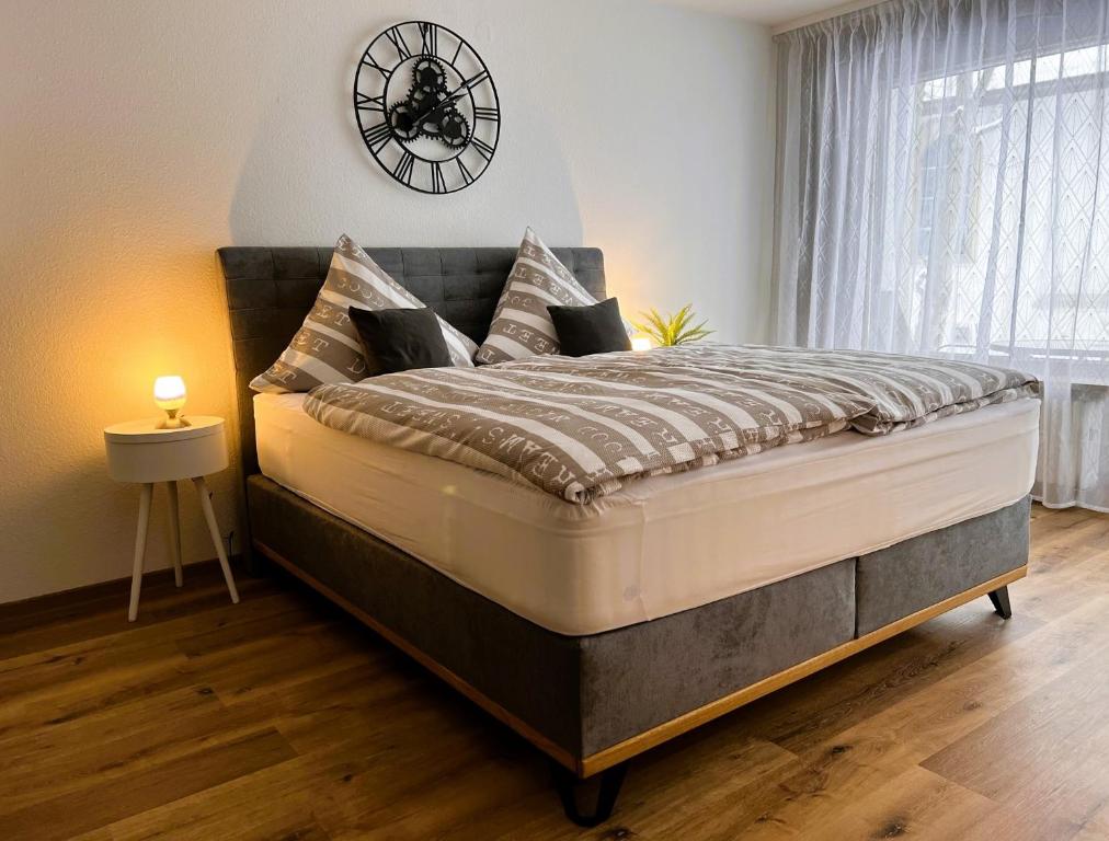 蒂蒂湖-新城Ferienwohnung Traumwerk Titisee的卧室配有一张大床,墙上挂着时钟