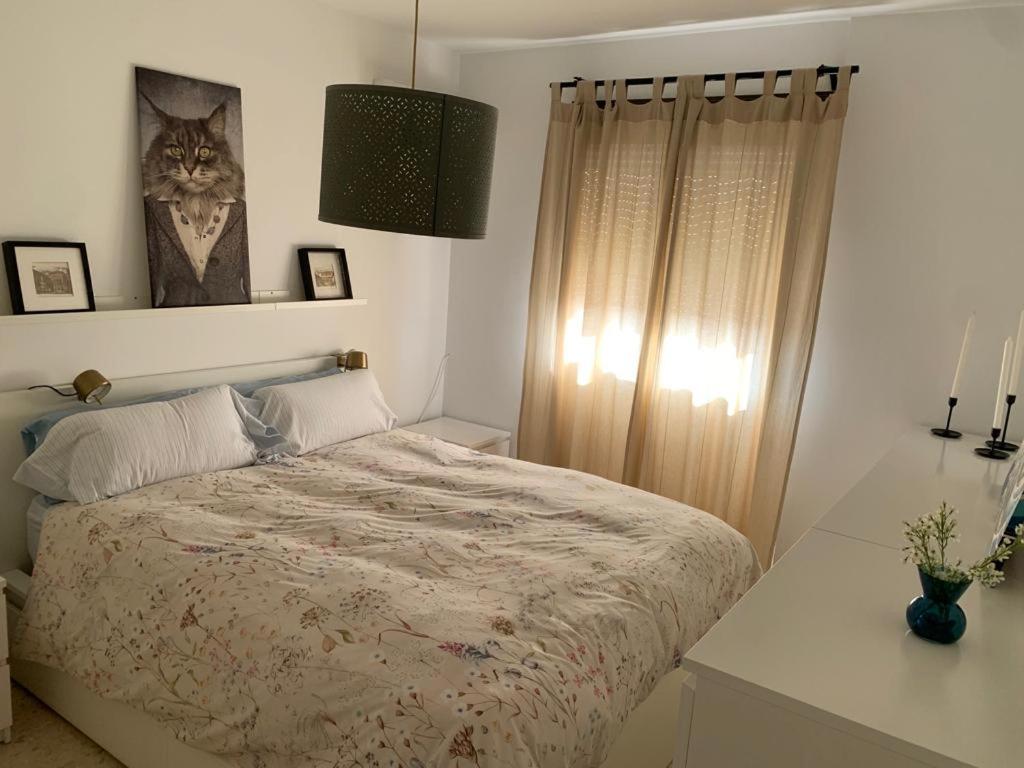 拜纳Apartamento Al Andalus的卧室配有一张床,墙上挂着一张猫的照片