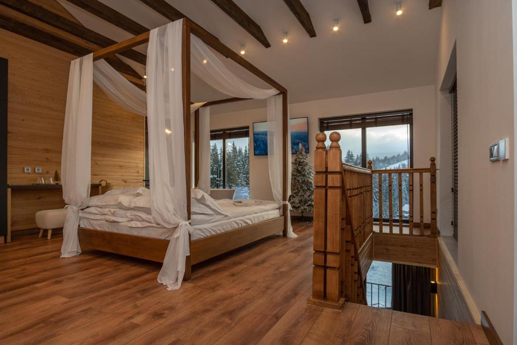 亚布卢尼齐亚Chillax Chalet的一间卧室设有天蓬床和楼梯。