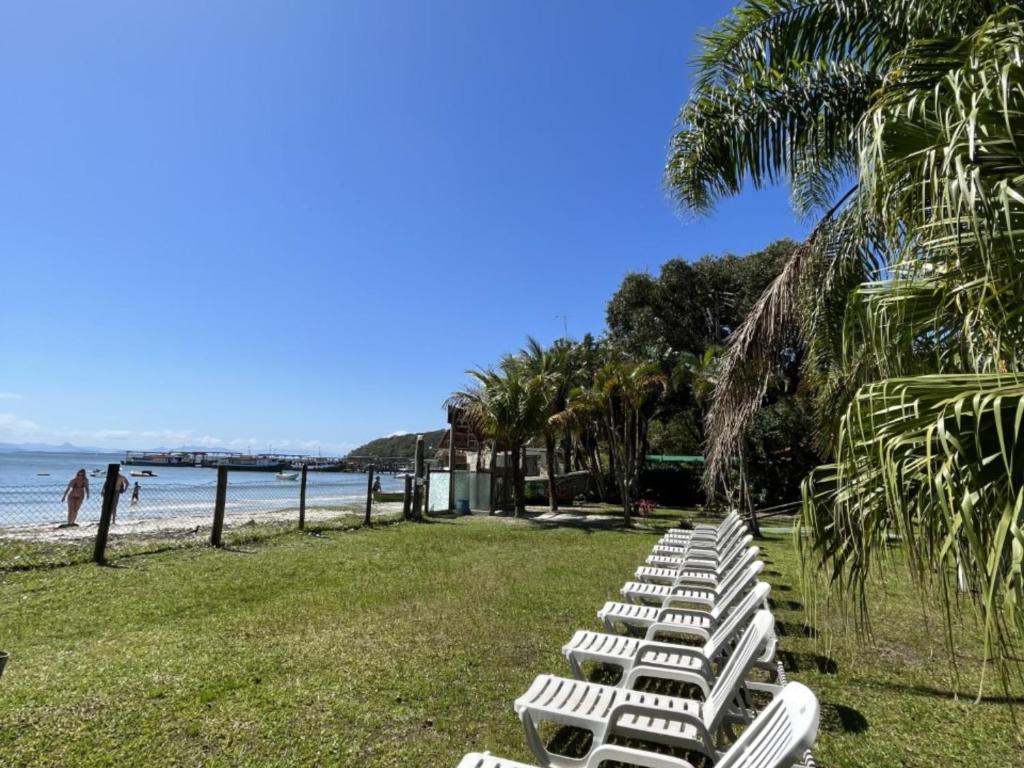 蜜岛A Ilha Verde Hotel Pousada na Praia的海滩上一排白色躺椅