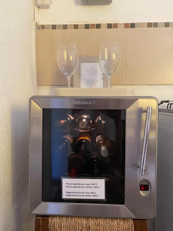 科洛尼亚-德尔萨克拉门托Casa Calma的两杯酒杯和一台带机器的小电视