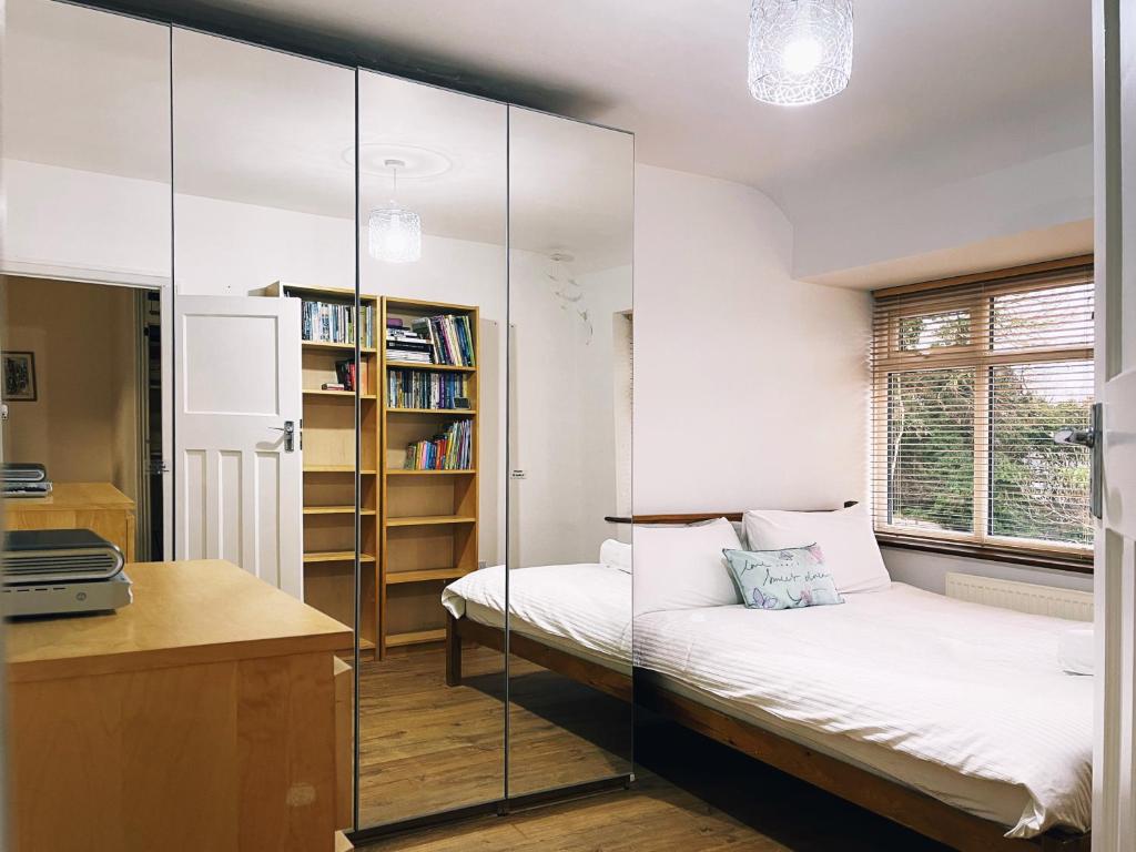 亨顿Jenny's Place的一间卧室设有两张床和玻璃墙