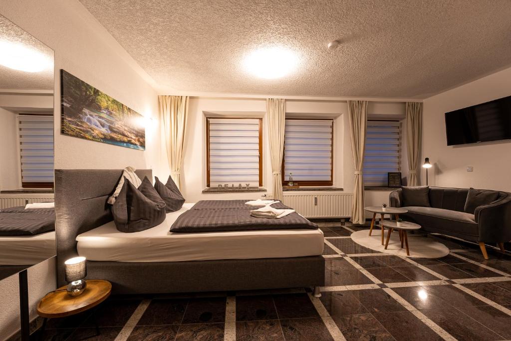 弗赖贝格Pension Krone的客房设有两张床、一张沙发和一台电视。