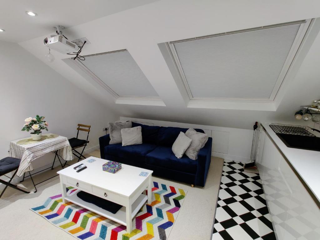 伦敦Jacuzzi Suite的客厅配有蓝色的沙发和桌子