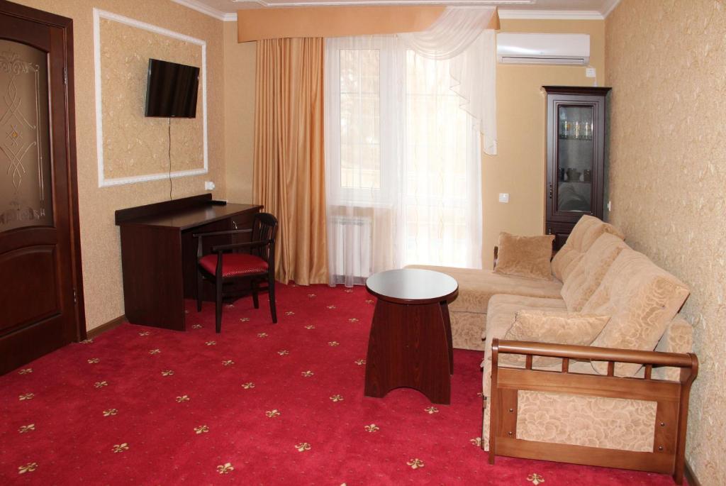 戈卢比茨卡亚Hotel Premier的带沙发和钢琴的客厅