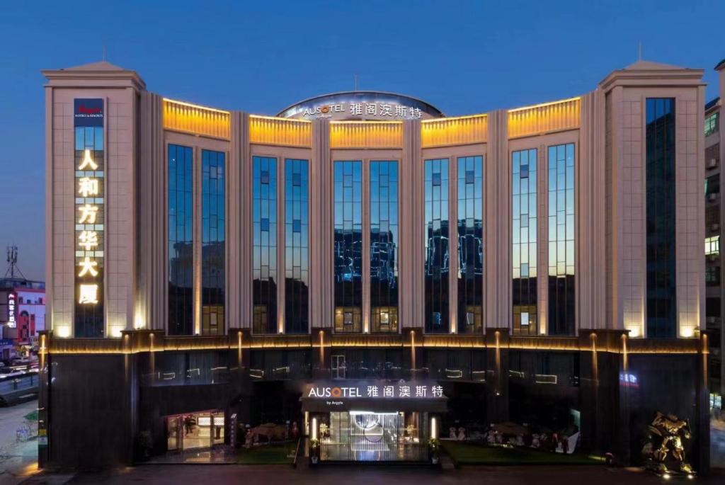 广州广州雅阁澳斯特酒店(白云国际机场人和地铁站店)的一座大型建筑,晚上有很多窗户