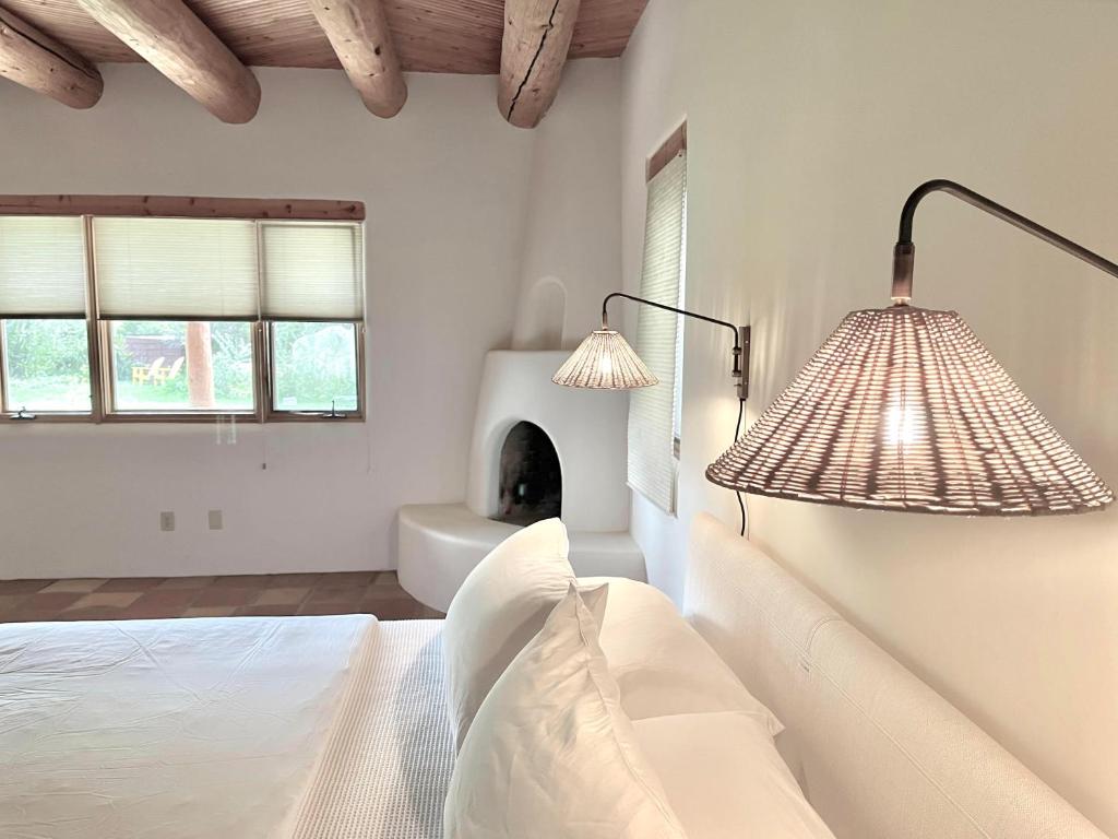 陶斯Hacienda Del Sol的一间卧室配有两盏灯、一张床和一个壁炉。