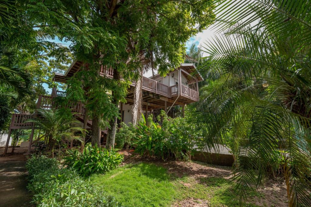 罗阿坦Exclusive Full House - 3 BDRM & 3 BATH - 3min Beach的树中间带阳台的房子
