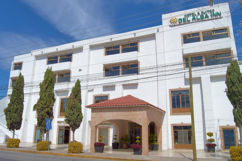 阿瓜斯卡连特斯Hotel del Alba Inn & Suites的前面有拱门的白色建筑