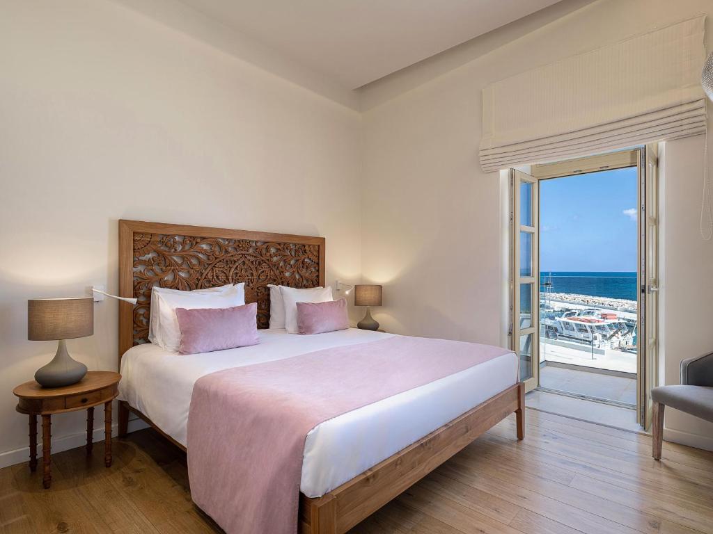 科林瓦里奥Avra Apartments Kolymbari Harbour的一间卧室设有一张床,享有海景