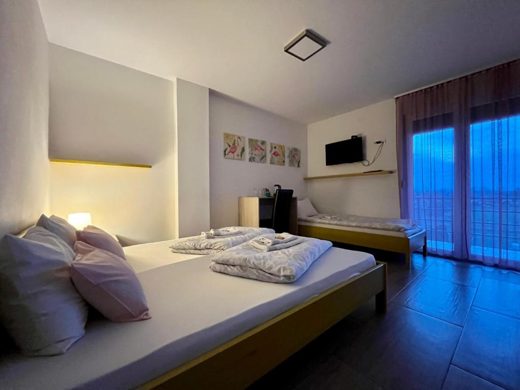 潘切沃Villa Ponte的酒店客房设有两张床和大窗户。