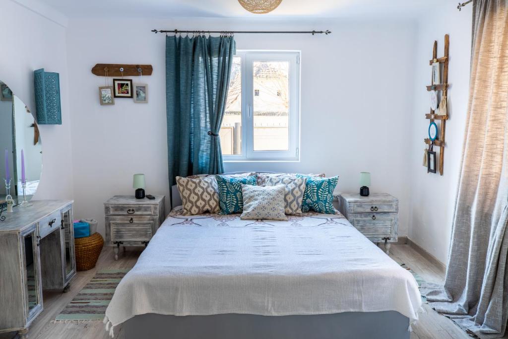 锡吉什瓦拉Casa Santa的一间卧室配有一张带蓝色窗帘的床和一扇窗户