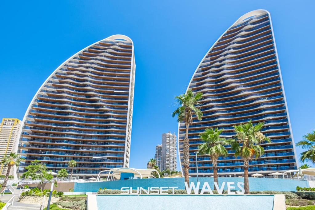 贝尼多姆Sunset Waves 3-194 Poniente Beach Resort的两座棕榈树城市的高楼