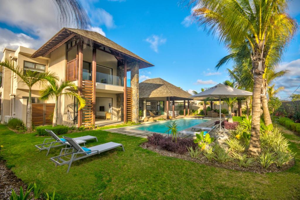 格兰高伯Mythic Suites & Villas的一座别墅,设有游泳池和棕榈树