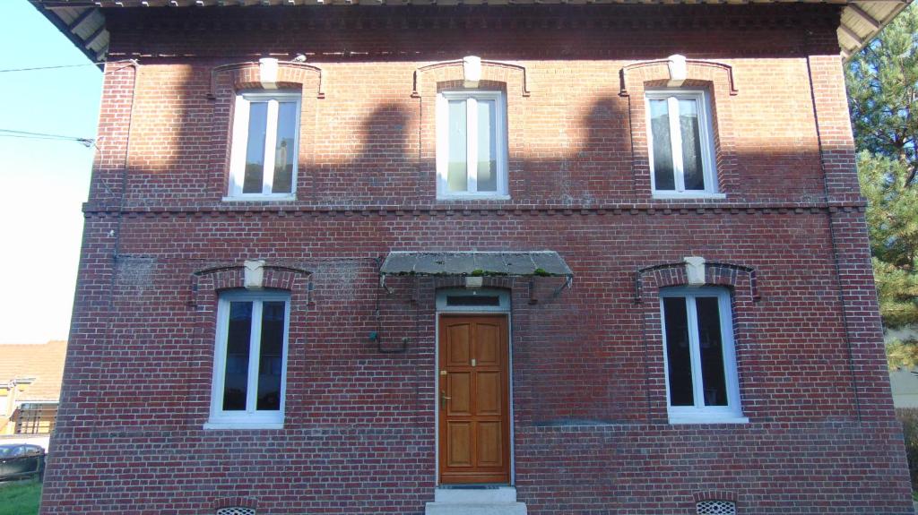 Le Petit-CouronneLes Pommerets的红砖建筑,上面有棕色的门