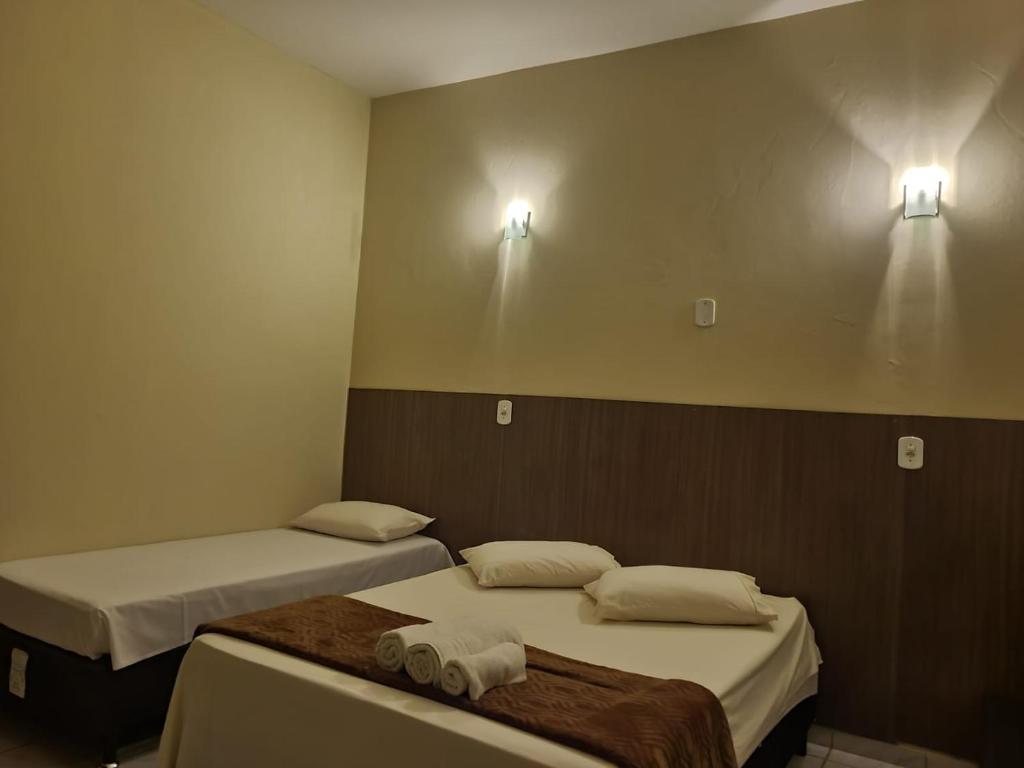 博尼图Pousada Rancho Bonito的两张床位于带两盏灯的墙上。