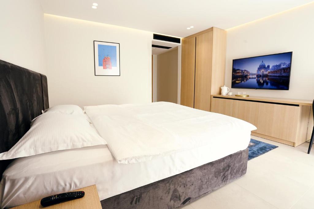 GjakoveHOTEL 12的卧室配有一张白色大床和电视。