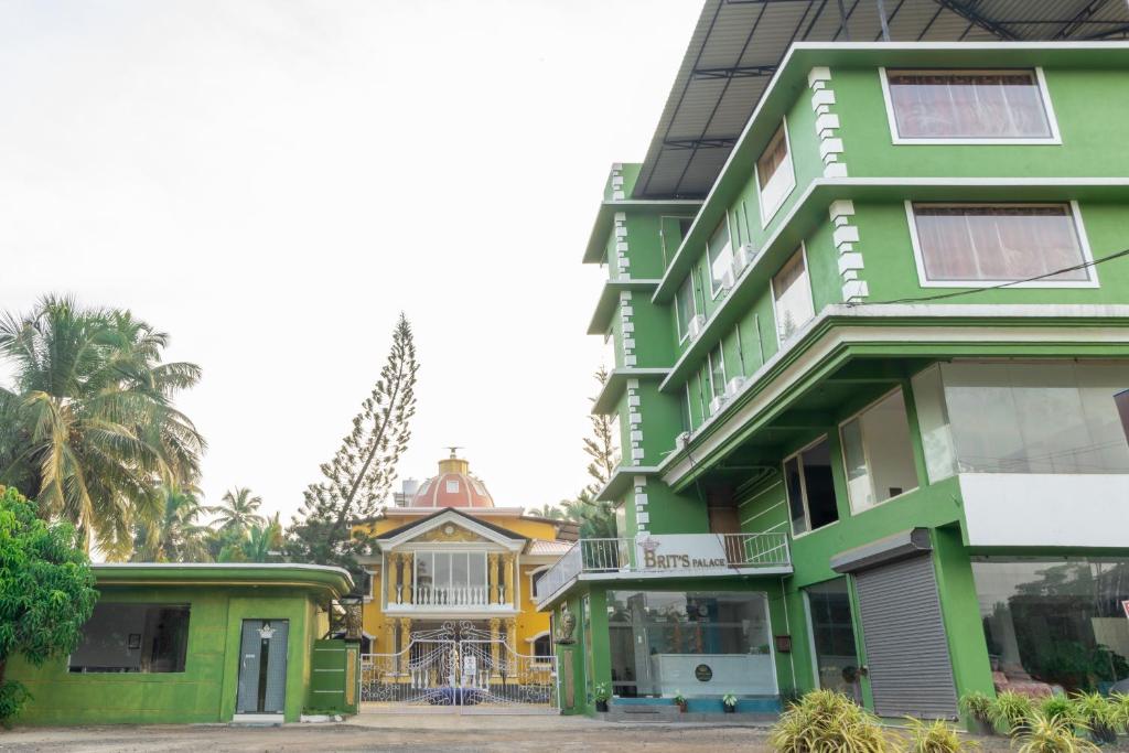 AgacaimBrit's Palace Goa的绿色建筑,有房子的背景