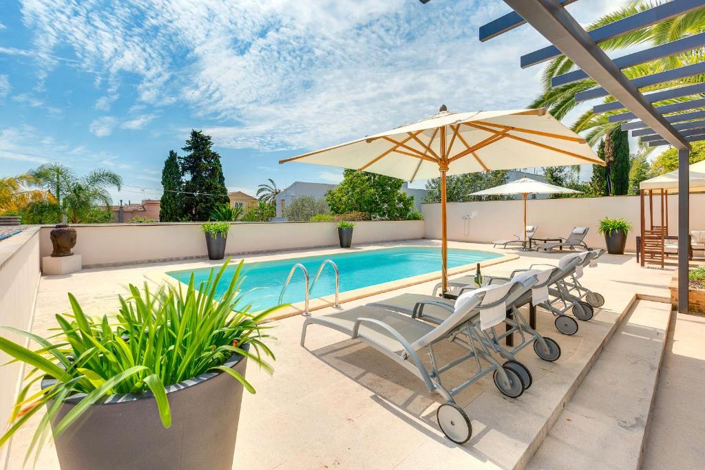 马略卡岛帕尔马Guesthouse Palma - Suite Arabella Apartment, Adults Only的一个带两把椅子和遮阳伞的游泳池