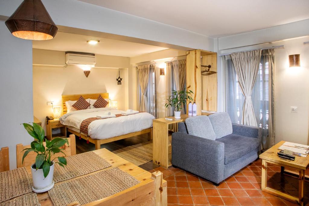 帕坦Hotel Timila的配有一张床和一把椅子的酒店客房