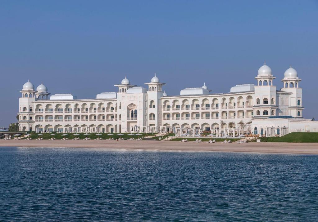 多哈The Chedi Katara Hotel & Resort的水体旁的白色大建筑