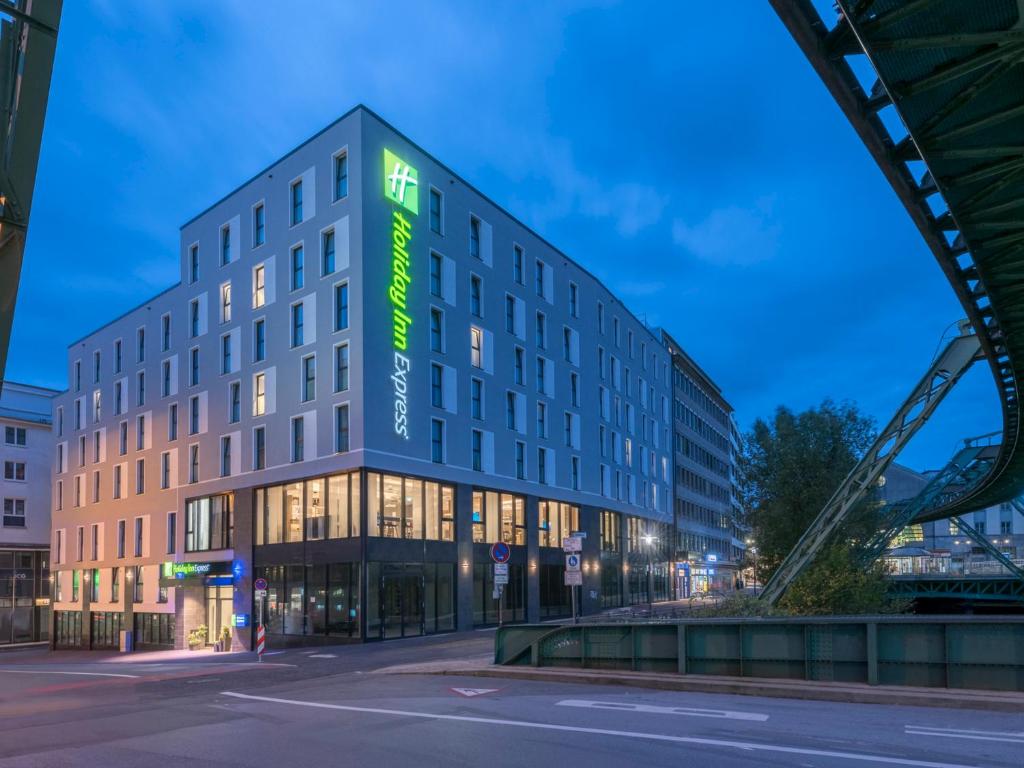 伍珀塔尔Holiday Inn Express - Wuppertal - Hauptbahnhof, an IHG Hotel的建筑的一侧有绿色标志