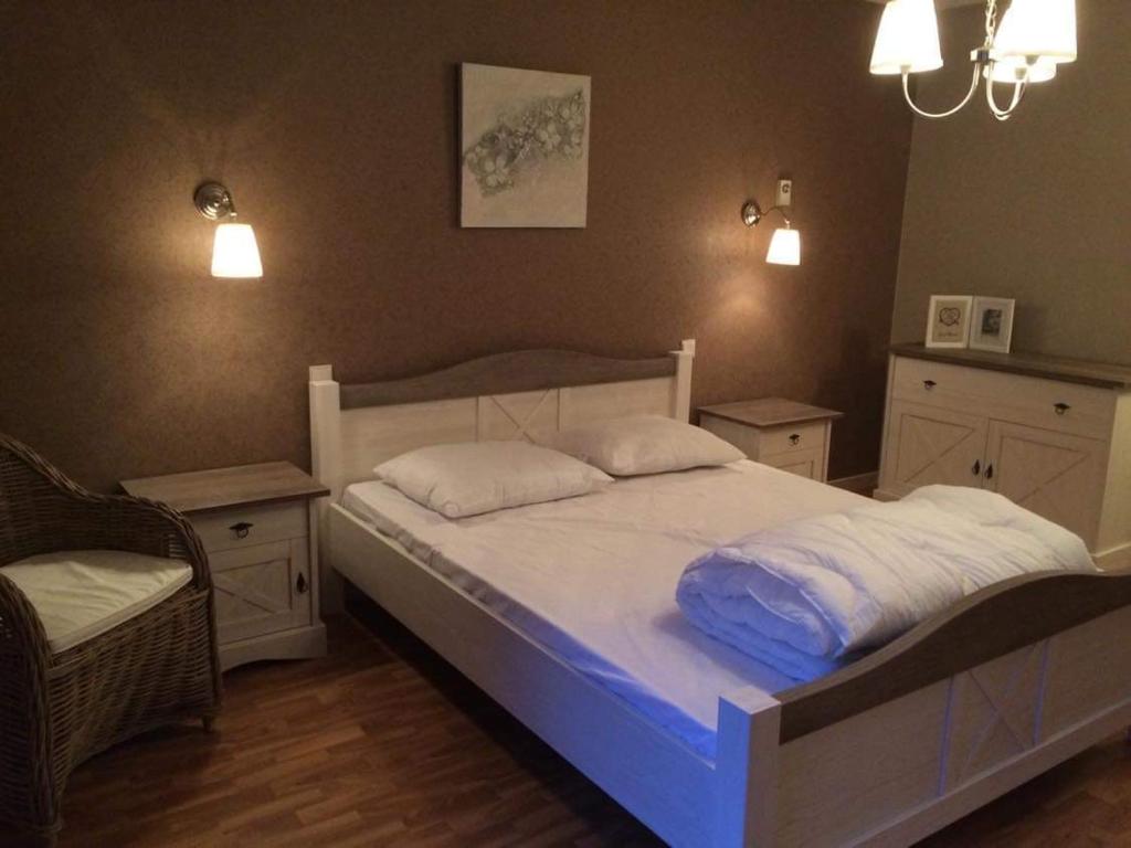 瑟穆瓦河畔夫雷斯Balcons de la Semois的一间卧室配有带2个枕头和椅子的床