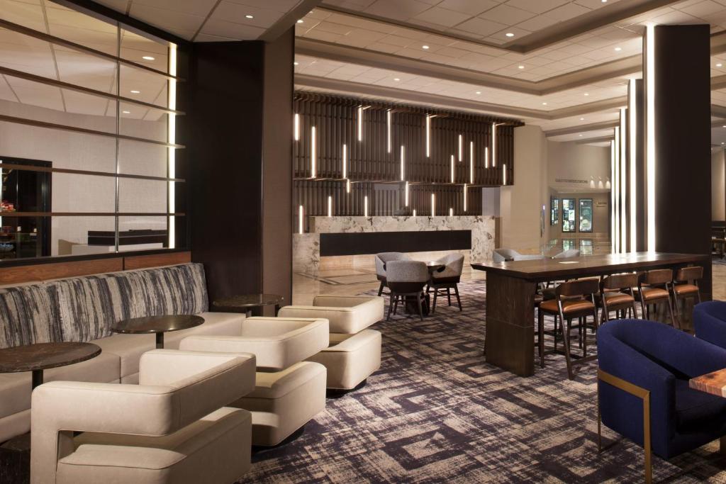 欧文Dallas/Fort Worth Airport Marriott的大堂设有酒吧和桌椅