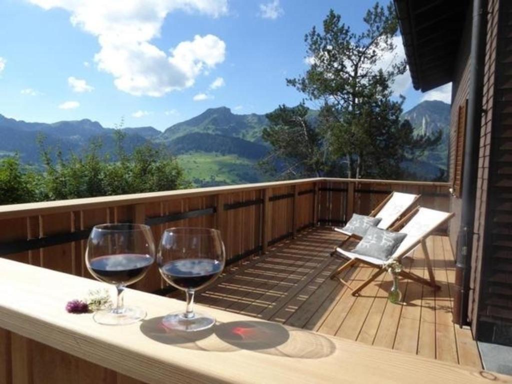 安特瓦塞尔Ferienhaus Oberguet的阳台上的桌子上放着两杯葡萄酒