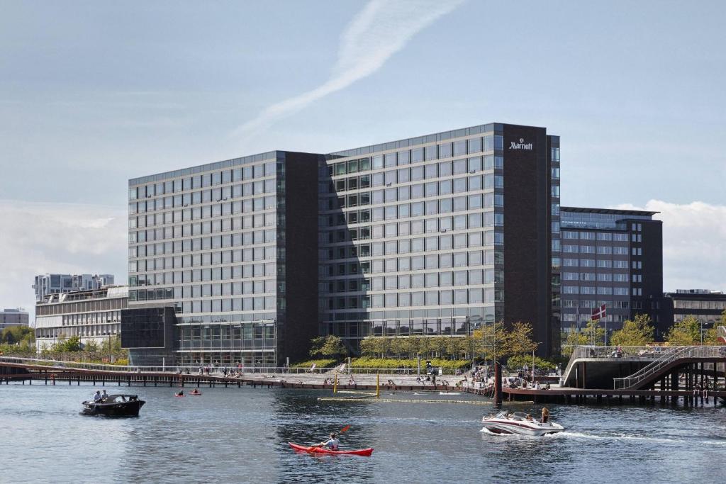 哥本哈根哥本哈根万豪酒店的两艘船在大楼前的河里