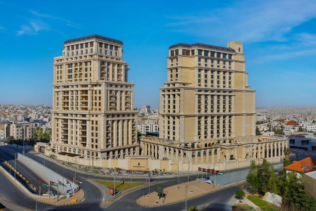 安曼The Ritz-Carlton, Amman的两座高楼,位于一个街道上