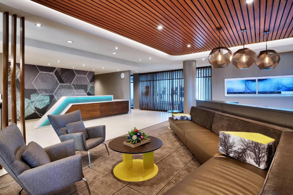 埃尔帕索SpringHill Suites by Marriott El Paso Airport的一个带沙发和椅子的大堂以及一个游泳池