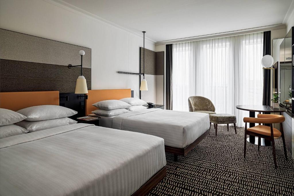 柏林柏林万豪酒店的酒店客房设有两张床和一张桌子。