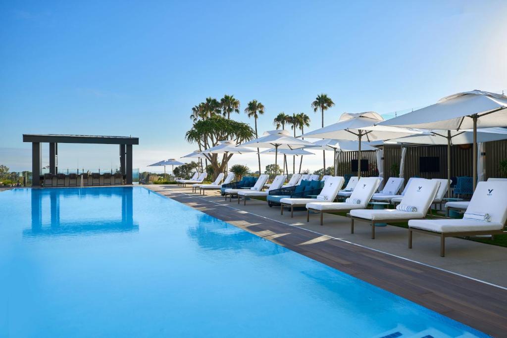 纽波特海滩VEA Newport Beach, a Marriott Resort & Spa的一个带白色躺椅和遮阳伞的游泳池