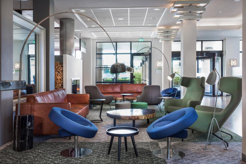 霍夫多普阿姆斯特丹机场万怡酒店的大堂配有沙发、椅子和桌子