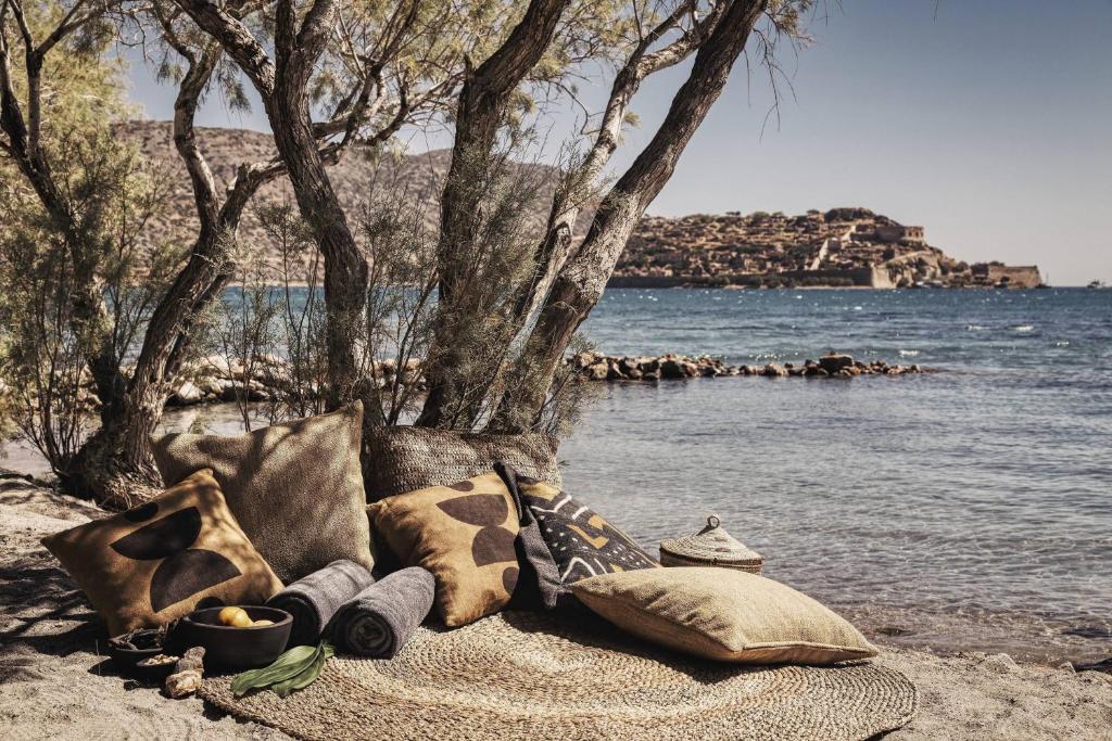 伊罗达伊罗达多姆斯傲途格精选酒店的水边海滩上的毯子和枕头